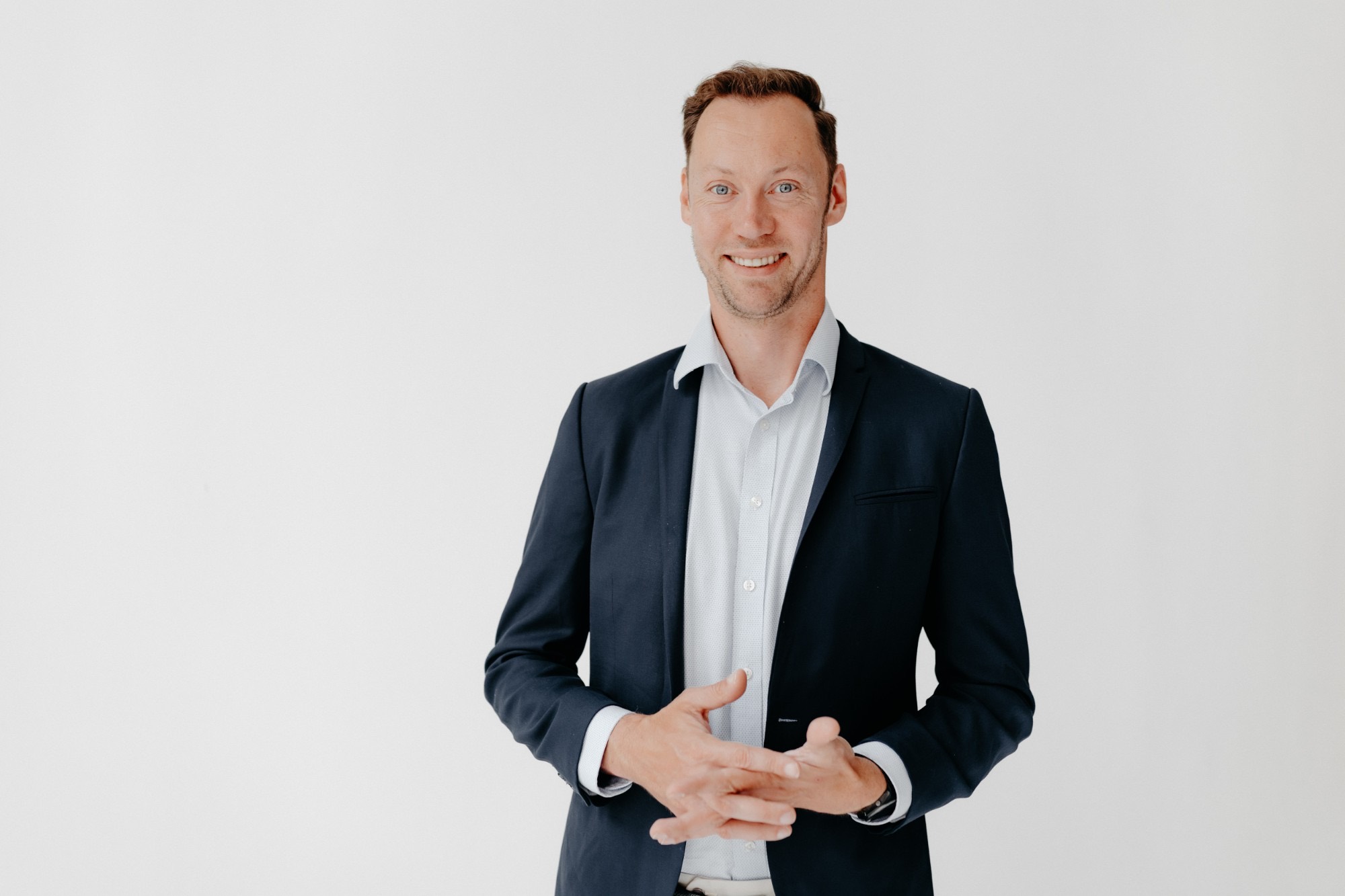 Philipp Schett in a navy blazer, smiling